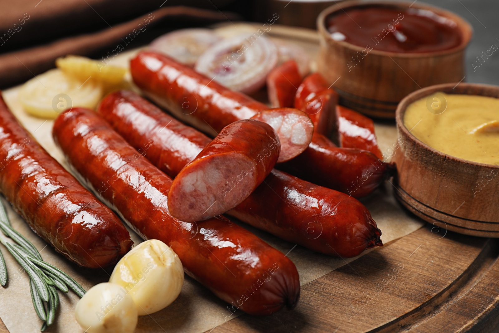 Photo of Delicious grilled sausages and vegetables on grey table, closeup