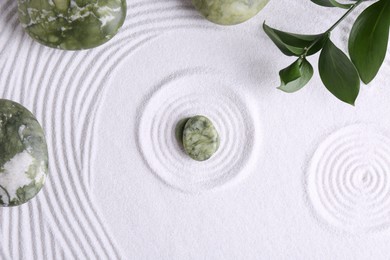 Zen concept. Stones, leaves and pattern on white sand, flat lay