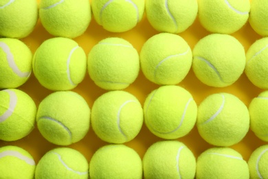 Photo of Tennis balls on yellow background, flat lay. Sports  equipment