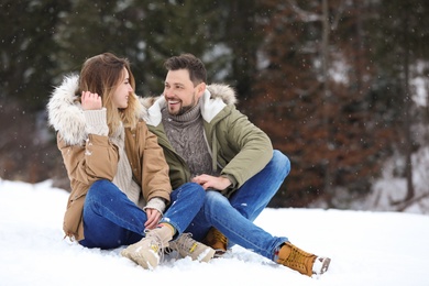 Photo of Couple spending time outdoors on snowy day. Winter vacation