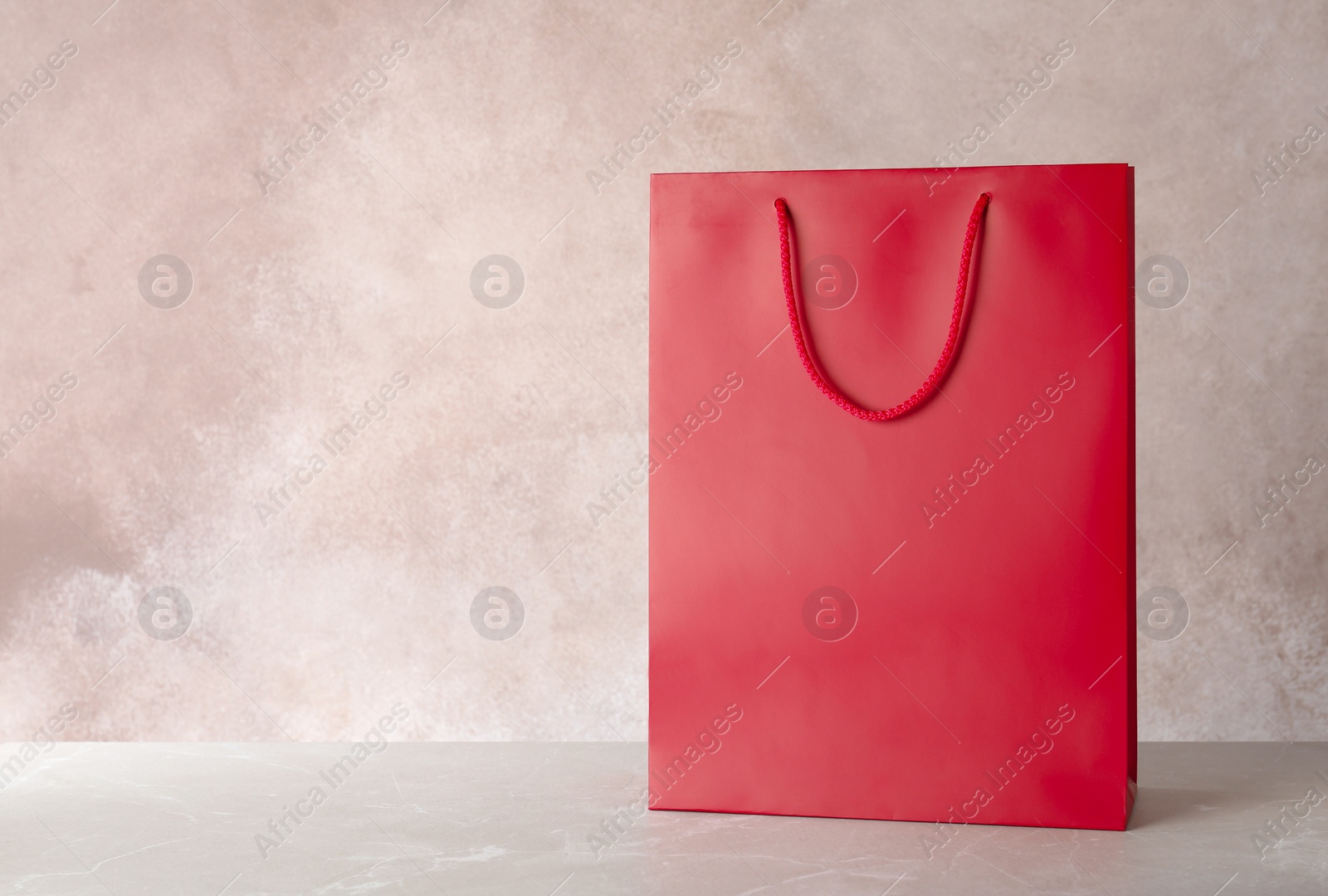 Photo of Mockup of paper shopping bag on table against color background