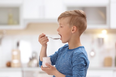 Photo of Little boy with yogurt on blurred background