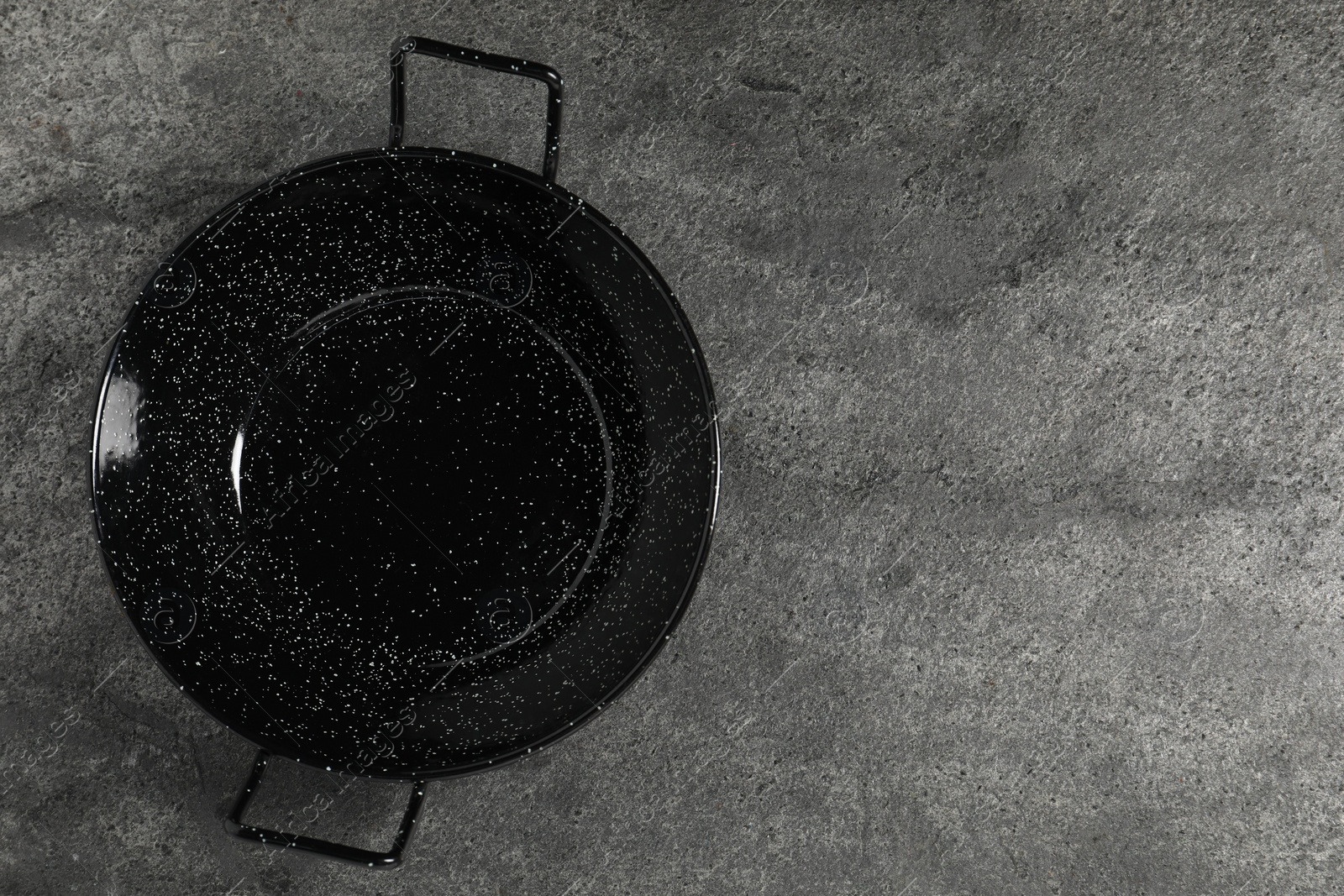 Photo of Empty iron wok on grey table, top view. Space for text