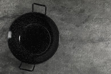 Photo of Empty iron wok on grey table, top view. Space for text