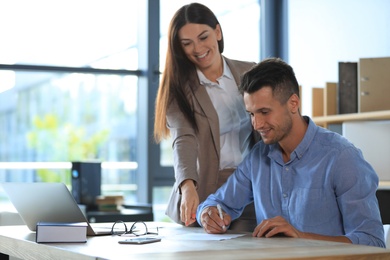 Photo of Female business trainer coaching young man in office