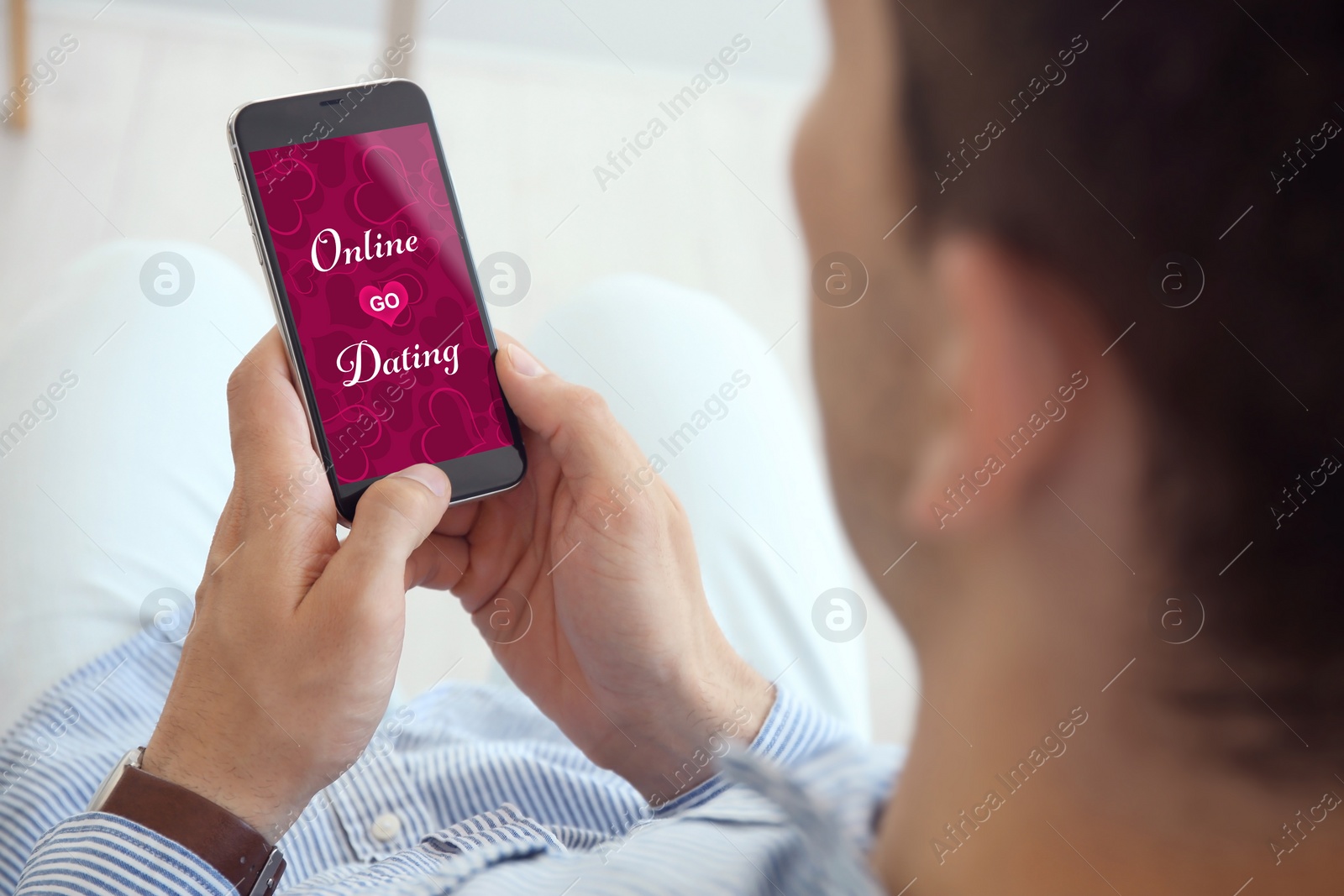 Image of Man visiting dating site via smartphone indoors, closeup