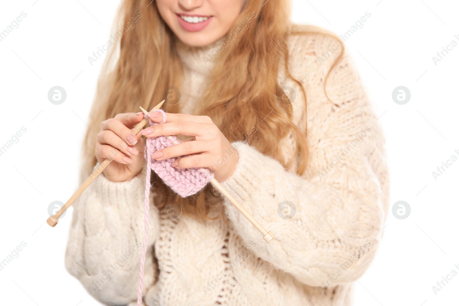 Photo of Young woman in cozy warm sweater knitting with needles on light background, closeup