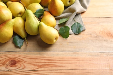 Ripe pears on wooden background, top view. Space for text