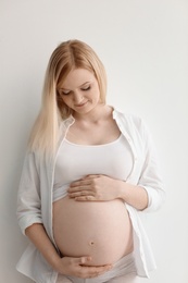 Photo of Portrait of beautiful pregnant woman on light background