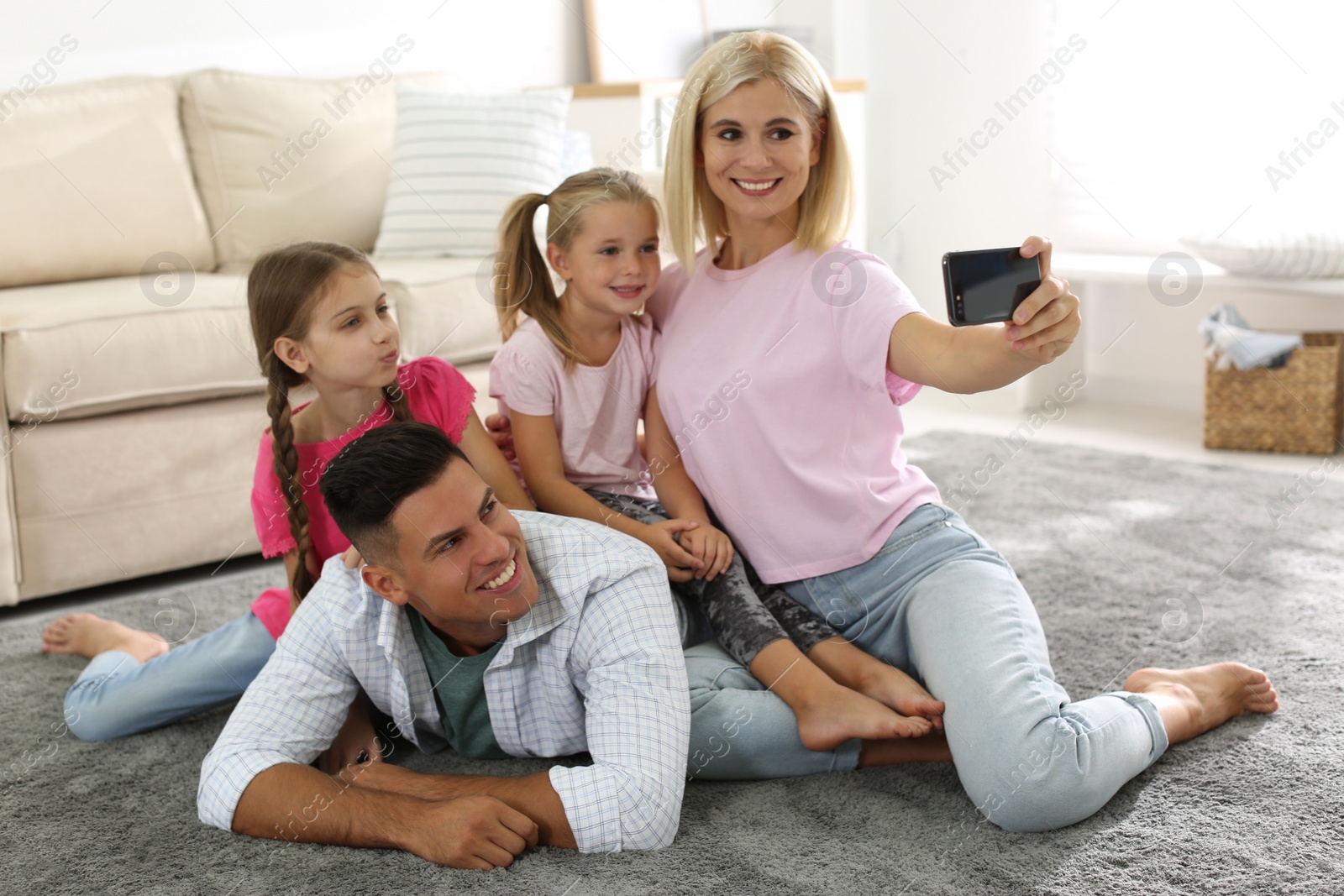 Photo of Happy family taking selfie on floor at home