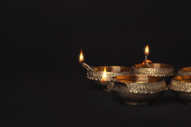 Photo of Diwali diyas or clay lamps on dark background