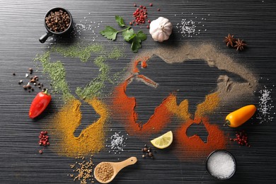 Photo of World map of different spices and products on black wooden table, flat lay