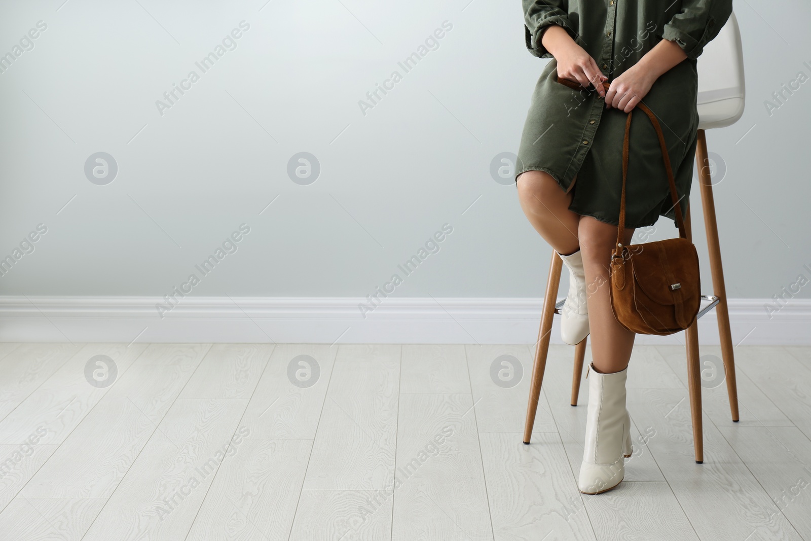 Photo of Woman wearing stylish leather shoes with bag indoors, closeup. Space for text