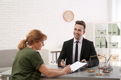 Photo of Young lawyer having meeting with senior client in office