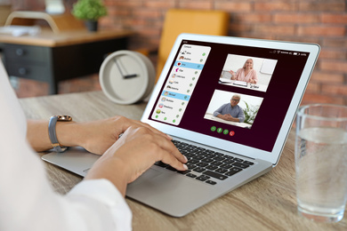 Woman having online meeting with her team via laptop, closeup