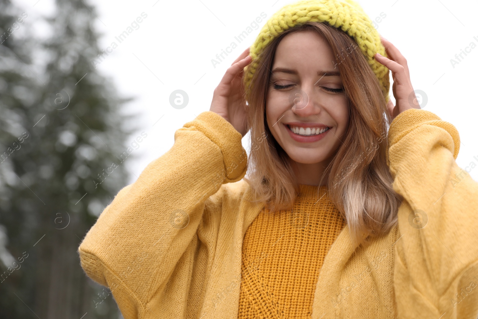 Photo of Young woman in warm clothes outdoors. Winter vacation