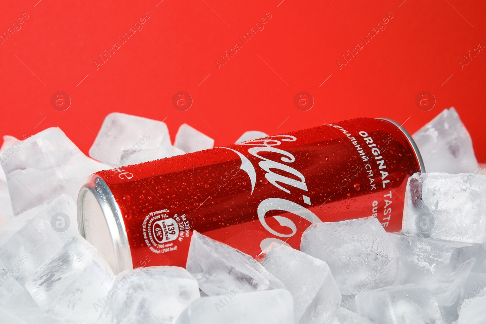 Photo of MYKOLAIV, UKRAINE - NOVEMBER 15, 2018: Coca Cola can on ice cubes against color background