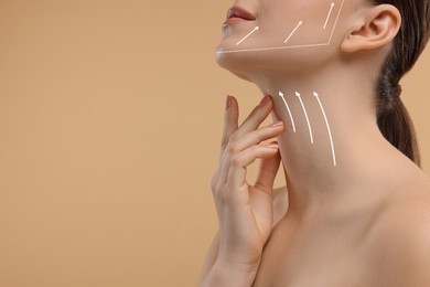 Woman with perfect skin after cosmetic treatment on beige background, space for text. Lifting arrows on her neck and face