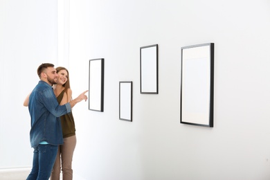 Young couple viewing exposition in modern art gallery