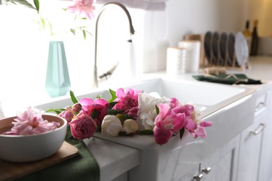 Bunch of beautiful peonies in kitchen sink