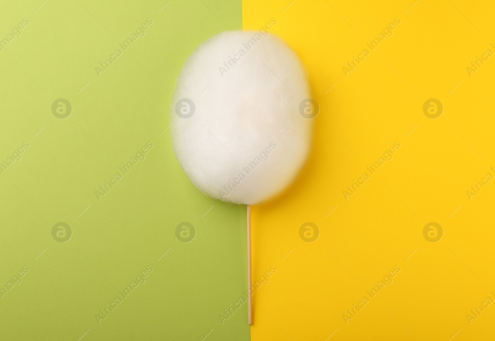 Photo of One sweet cotton candy on color background, top view