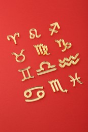 Shiny zodiac signs on red background, closeup