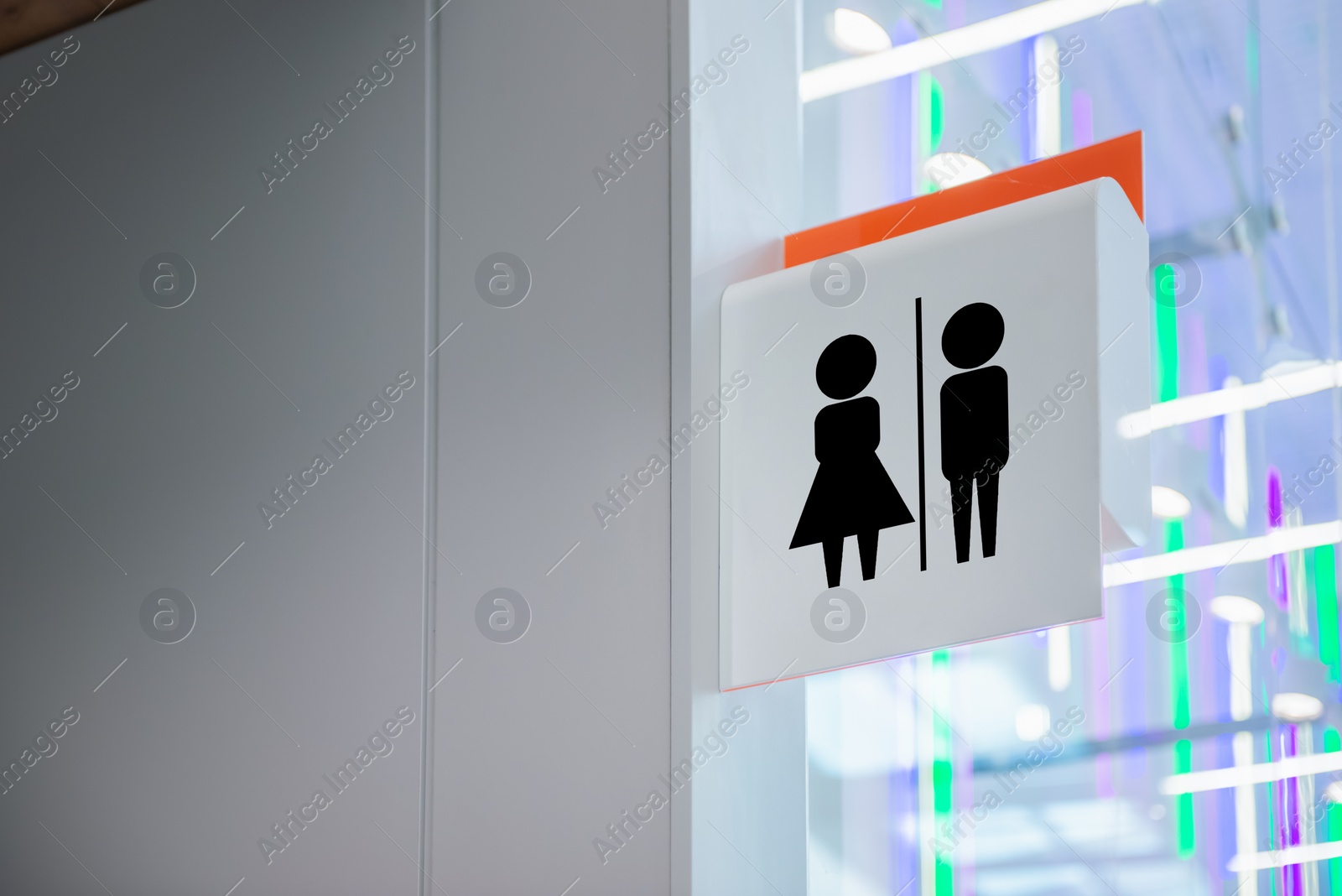 Image of White public toilet sign hanging on wall indoors