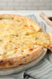 Delicious cut cheese pizza on table, closeup