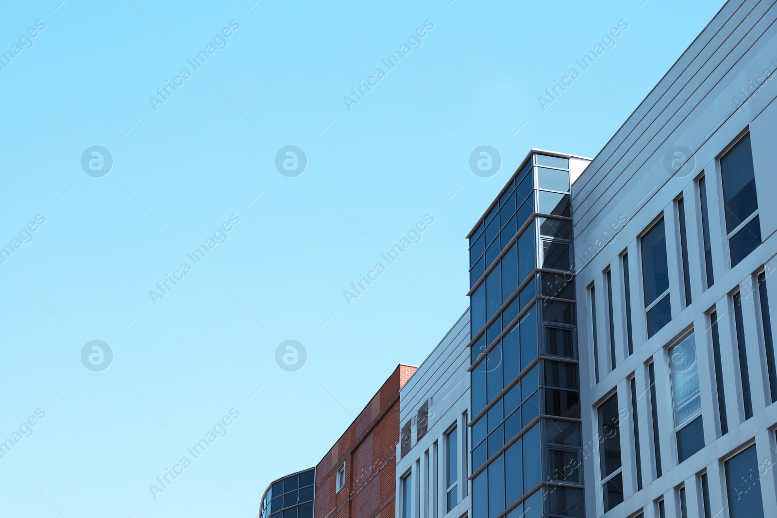 Photo of View of modern building against blue sky. Space for text