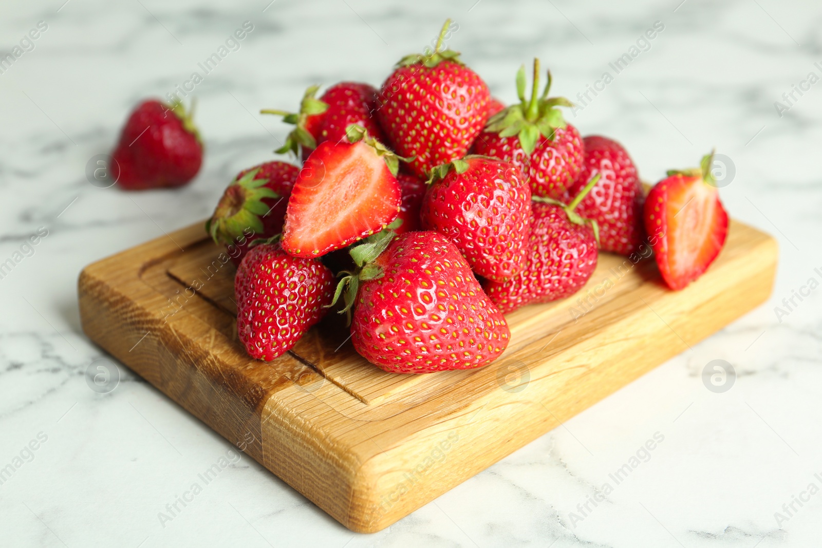 Photo of Delicious ripe strawberries on wooden board, closeup