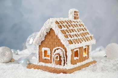 Photo of Beautiful gingerbread house decorated with icing on snow