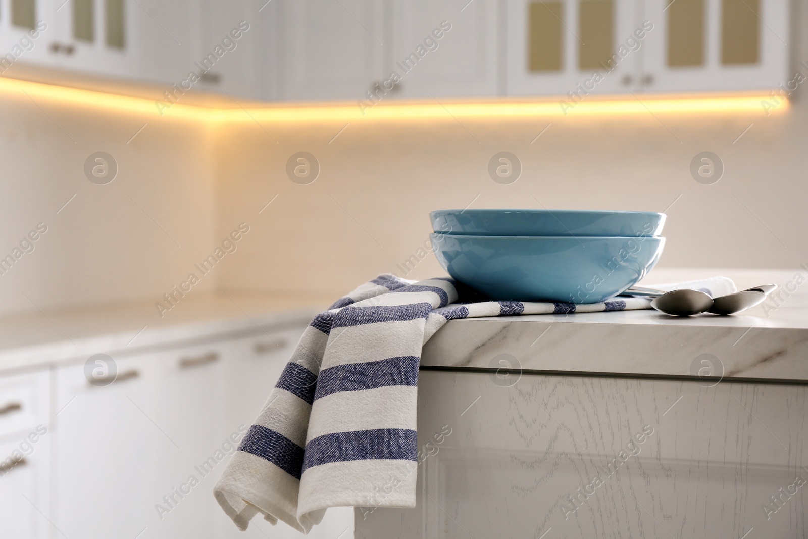 Photo of Kitchen towel and bowl on white table indoors, space for text