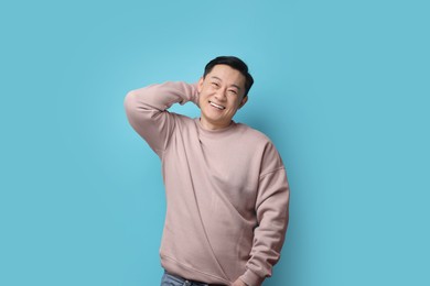 Portrait of happy man on light blue background