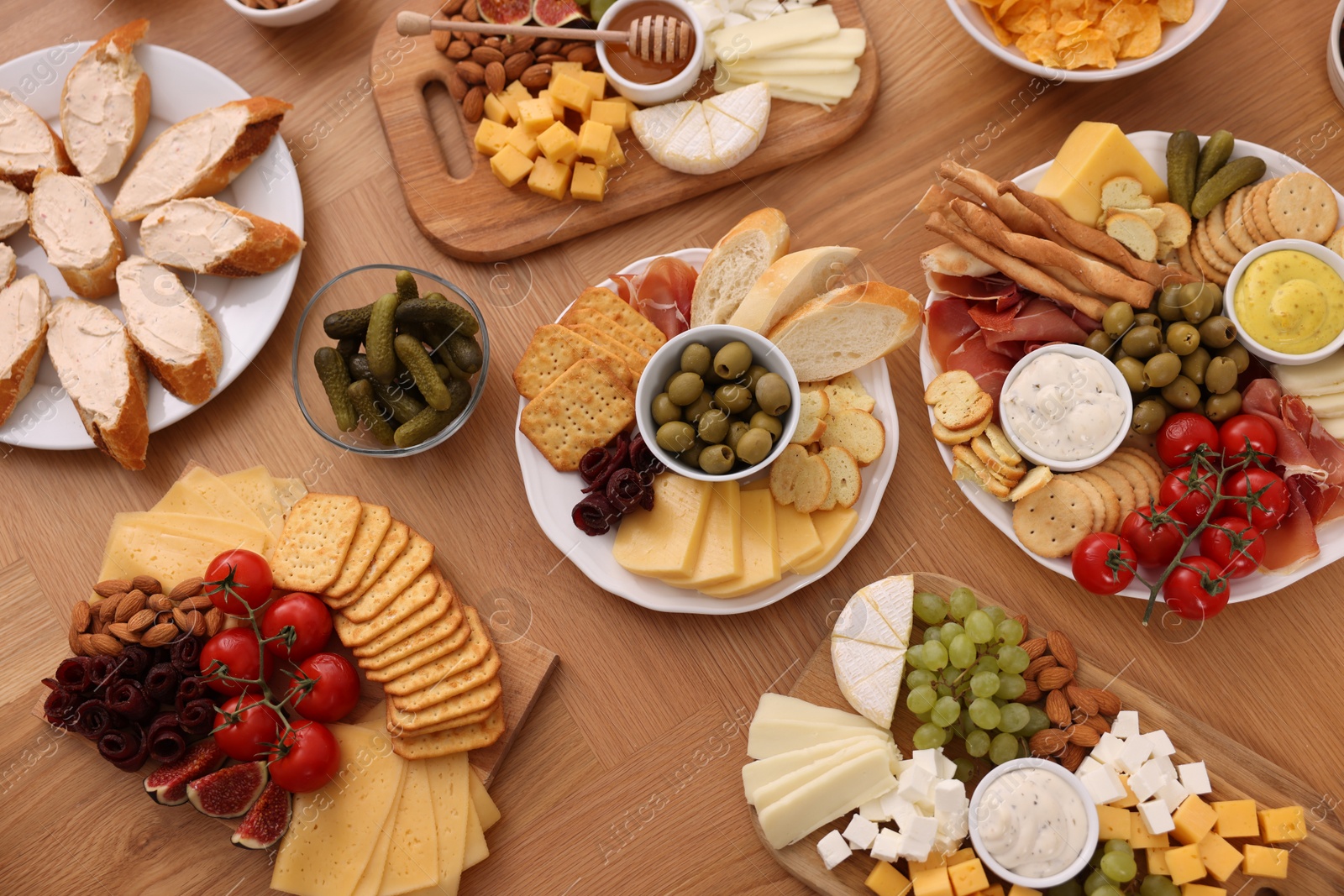 Photo of Assorted appetizers served on wooden table, flat lay