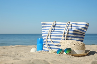 Stylish beach accessories on sandy sea shore