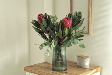 Vase with beautiful Protea flowers on table indoors