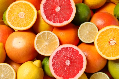 Different fresh citrus fruits as background, top view