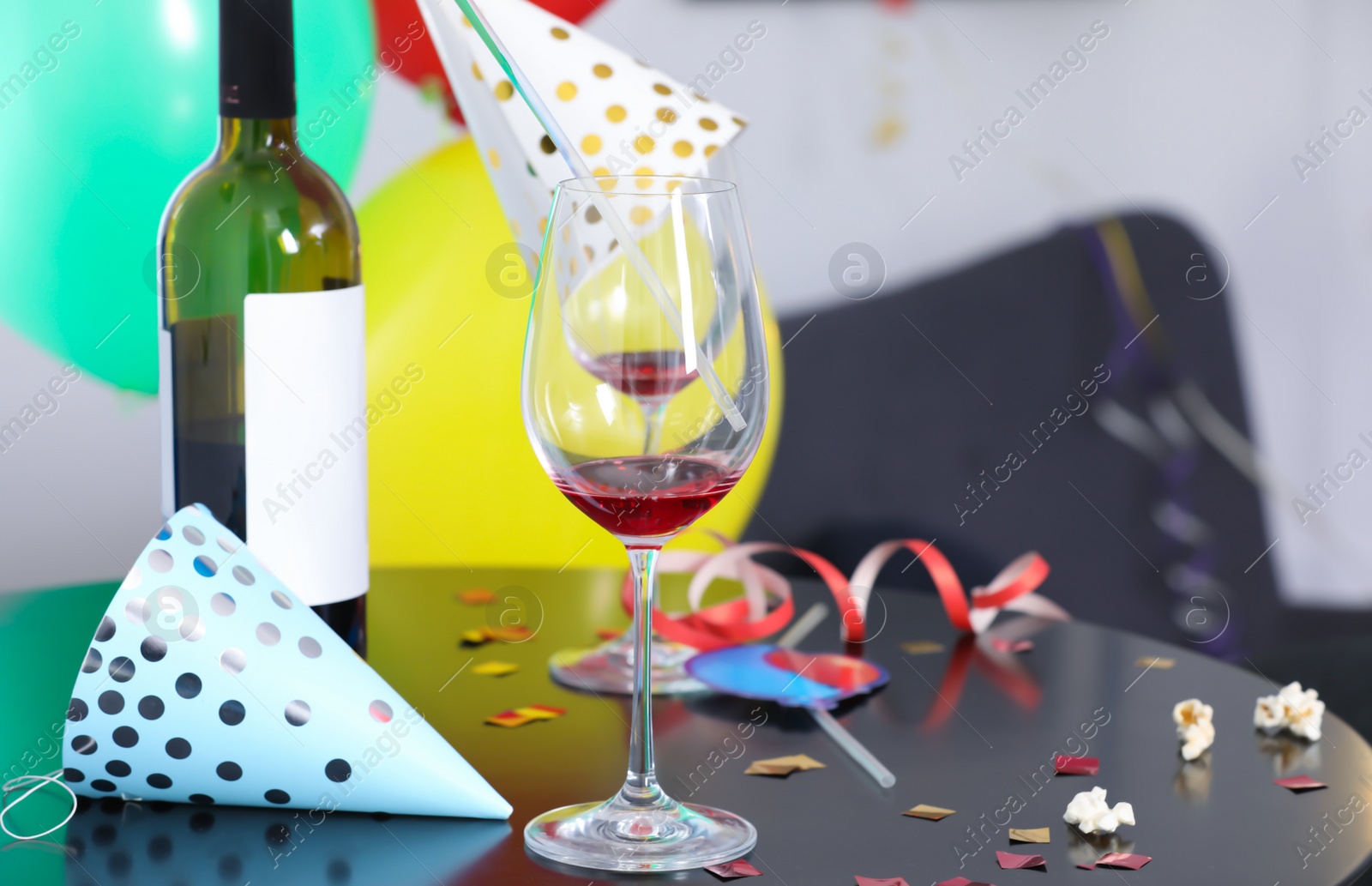 Photo of Messy table with bottle of wine and glasses against blurred background. After party chaos