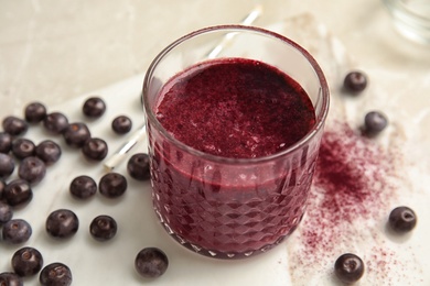 Photo of Glass with delicious acai smoothie on table, closeup