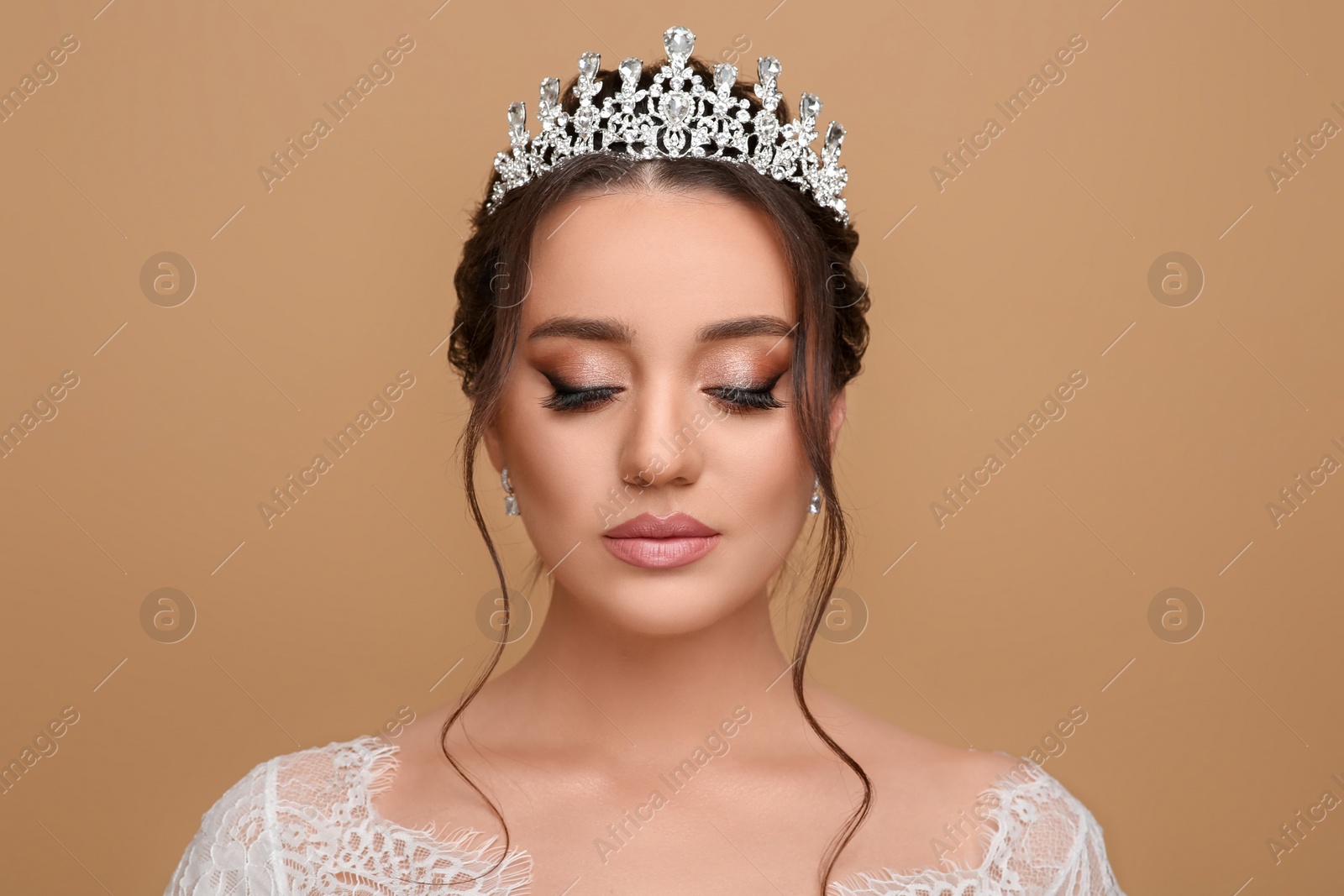 Photo of Beautiful young woman wearing luxurious tiara on beige background