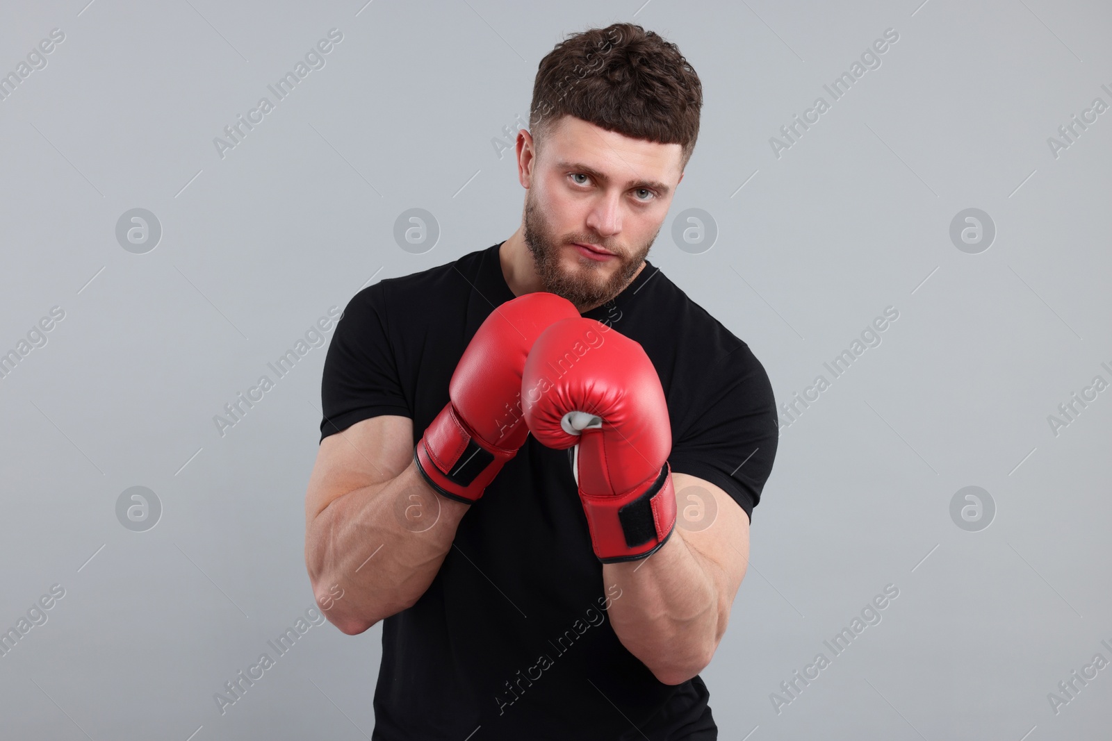 Photo of Man in boxing gloves on grey background