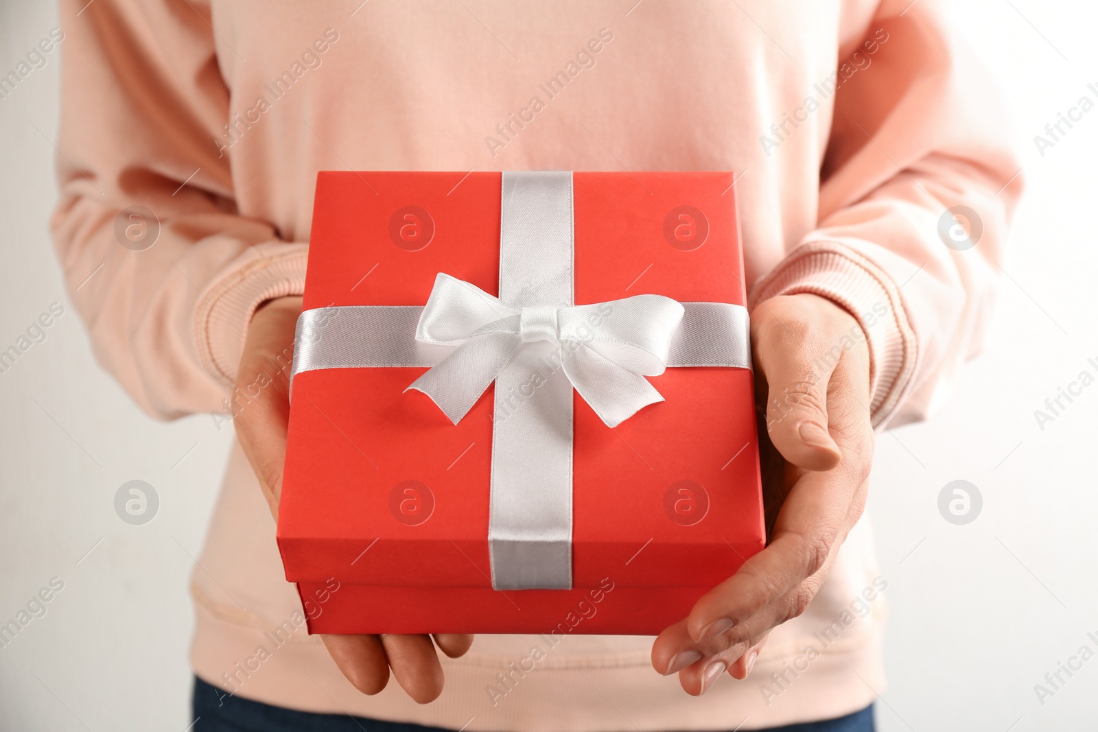 Photo of Woman holding gift box on white background, closeup. Valentine's Day celebration