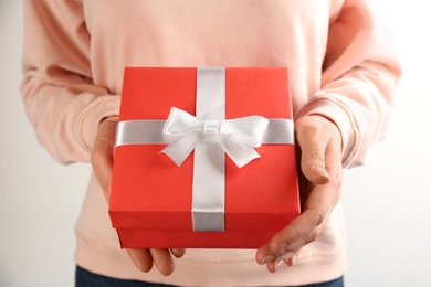 Photo of Woman holding gift box on white background, closeup. Valentine's Day celebration