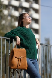 Young woman with stylish backpack on autumn day