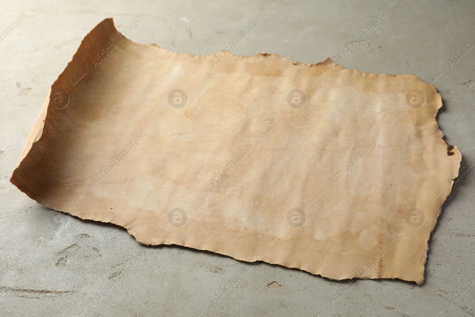 Photo of Sheet of old parchment paper on grey table