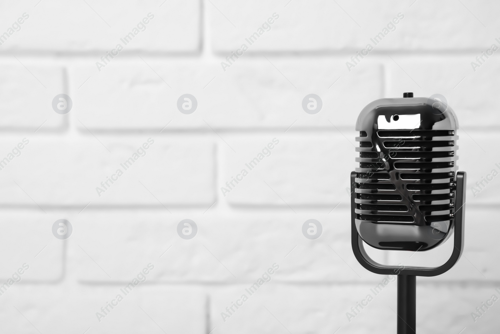 Photo of Retro microphone near brick wall. Space for text