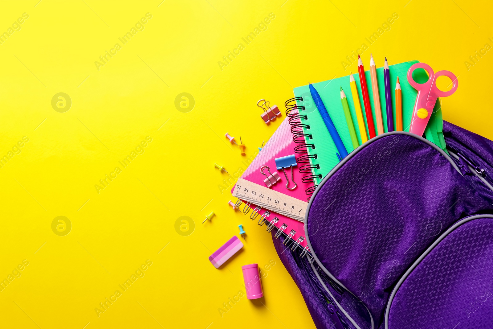 Photo of Flat lay composition with backpack and school stationery on color background
