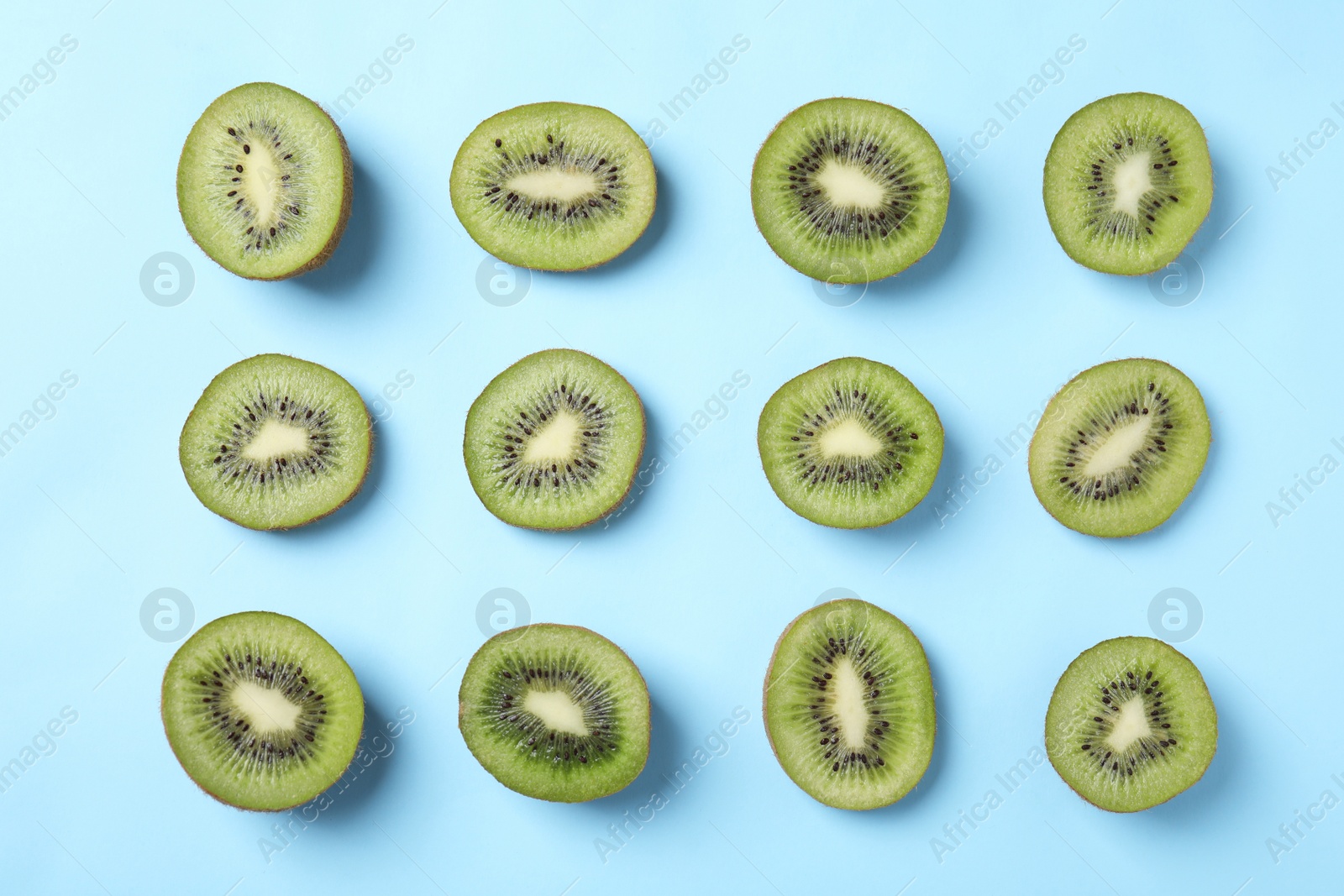 Photo of Top view of sliced kiwis on light blue background