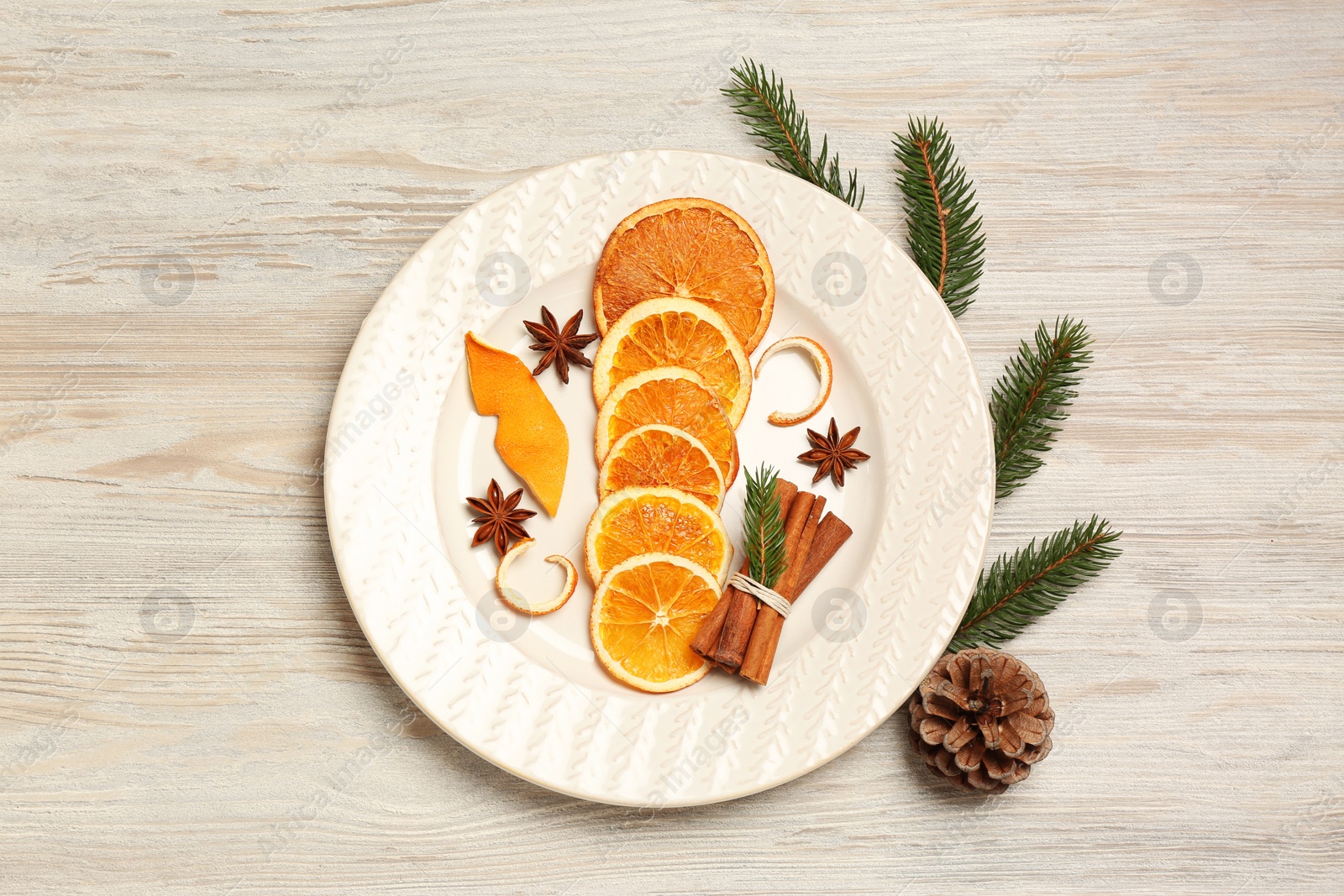 Photo of Flat lay composition with dry orange slices, anise stars, cinnamon sticks and fir branches on white wooden table, flat lay