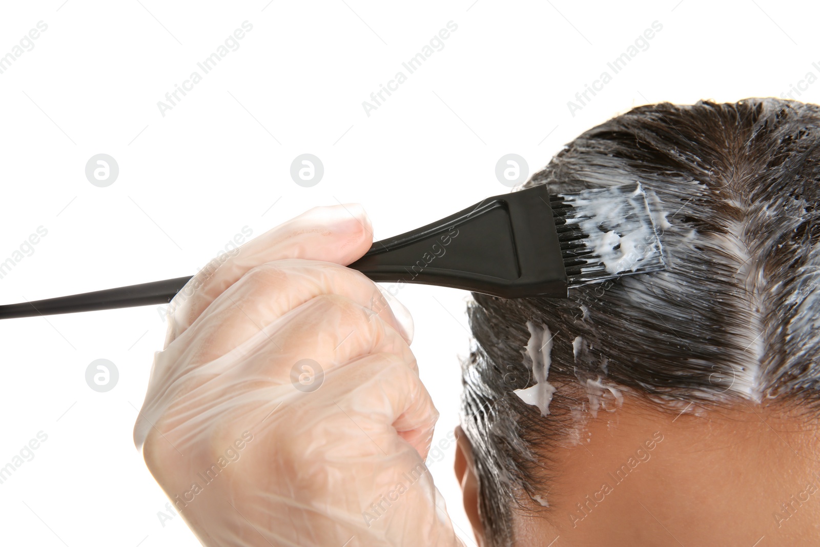 Photo of Young woman dyeing her hair against white background, closeup